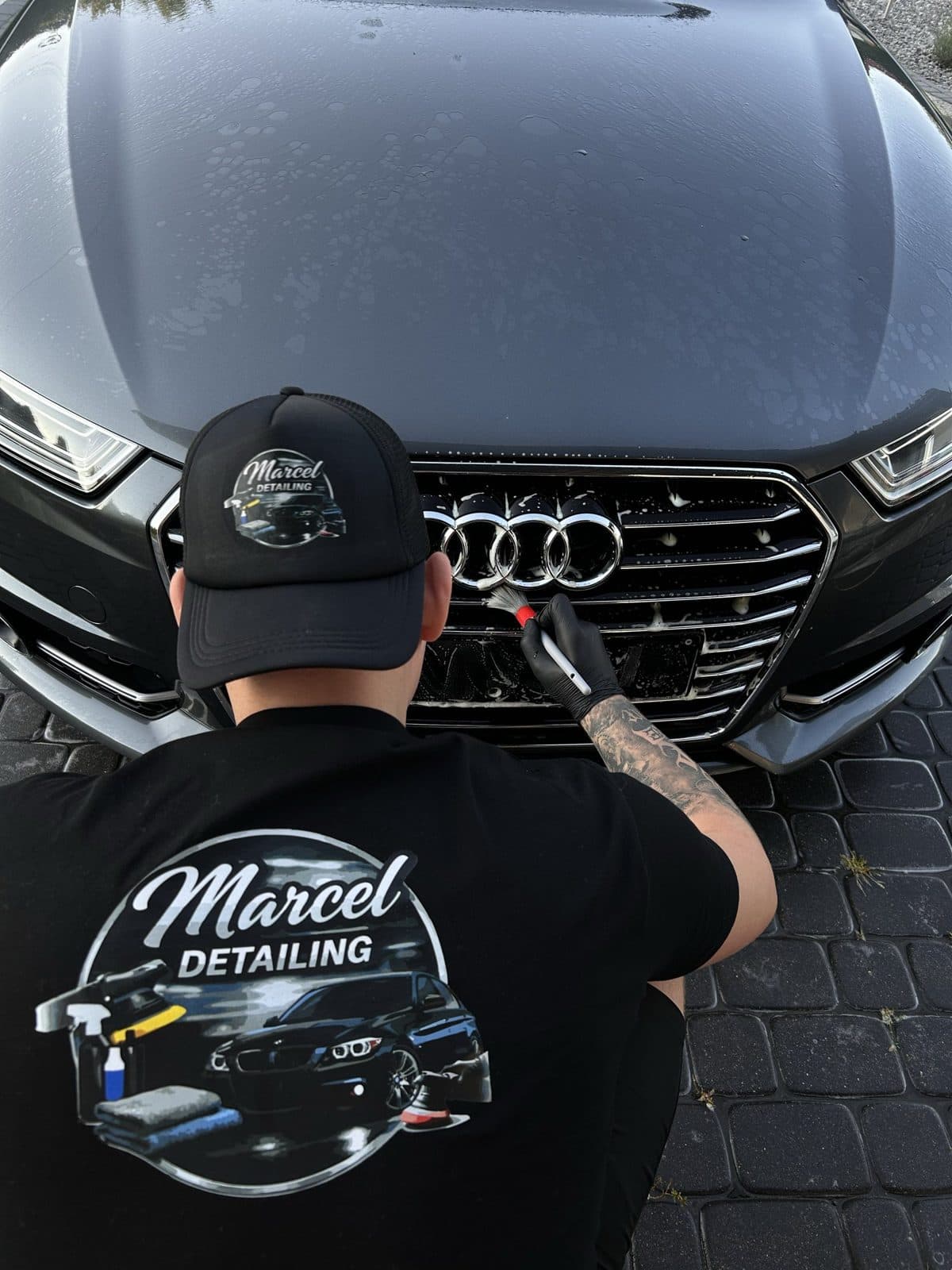 Marcel czyści grill Audi pędzelkiem detailingowym